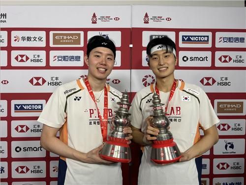 우승 트로피 들어 보이는 서승재-김원호(좌측부터)