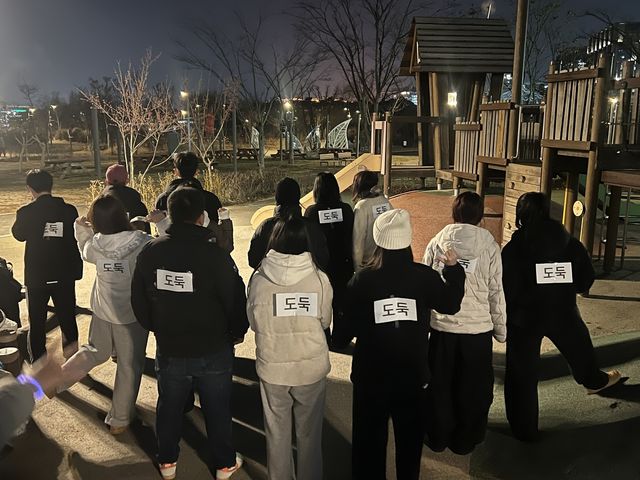 크리스마스이브인 24일 강서구 서울식물원 잔디밭에서 '경찰과 도둑' 놀이의 도둑 역할을 하기 위해 등에 종이를 붙인 사람들. [촬영 김유향 수습기자]