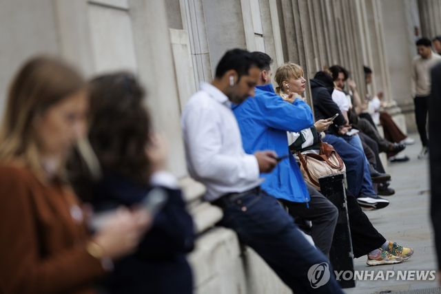휴대폰 들여다보는 런던 시민들