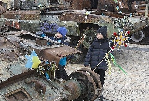 성탄절인 25일 우크라이나 소년이 키이우 시내에서 부서진 러시아 전차에 크리스마스 상징물을 부착하고 있다. [EPA 연합뉴스 자료사진] 