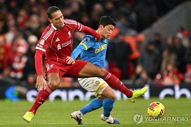 리버풀 수비수 판데이크와 경합하는 황희찬(오른쪽).