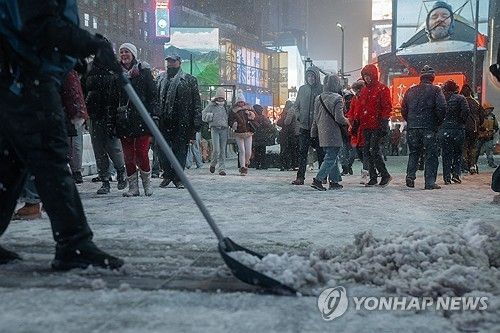 26일 뉴욕 타임스퀘어에서 눈 치우는 사람