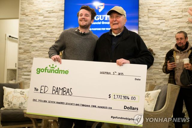 호주인 인플루언서 샘 바이덴호퍼가 5일(현지시간) 미국 미시간주의 88세 마트 계산원 에드 뱀버스에게 170만달러 상당의 기부증서를 전달하고 있다. [AP=연합뉴스 자료사진. 재판매 및 DB 금지]