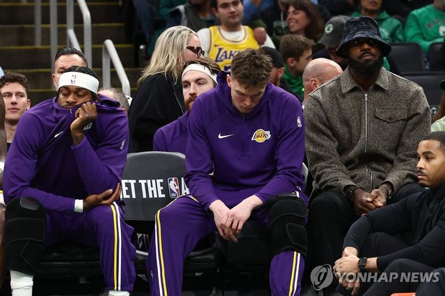 보스턴과의 경기 중 사복 차림으로 벤치에 앉아 있는 르브론 제임스(오른쪽)