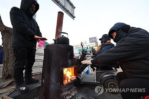 화목난로에 추위 녹이는 상인들