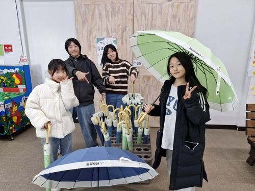  공유우산 사용하는 청소년들 