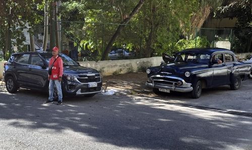 아바나 도로에 주차된 한국 브랜드 SUV와 올드카