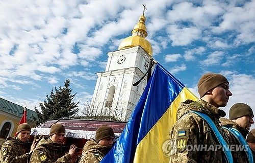 키이우 시내 성(聖)미카엘 수도원 앞에서 전우의 시신이 담긴 관을 옮기는 우크라이나군 병사들