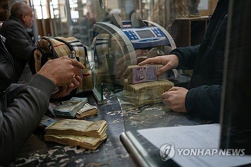 시리아 중앙은행에서 시리아 파운드화 지폐를 세는 직원의 모습