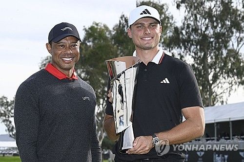 대회 주최자인 우즈(왼쪽)로부터 트로피를 받은 오베리.
