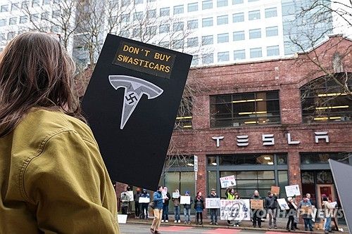 지난 15일(현지시간) 미 시애틀의 테슬라 전시장 앞에서 머스크에 반대하는 시위대 