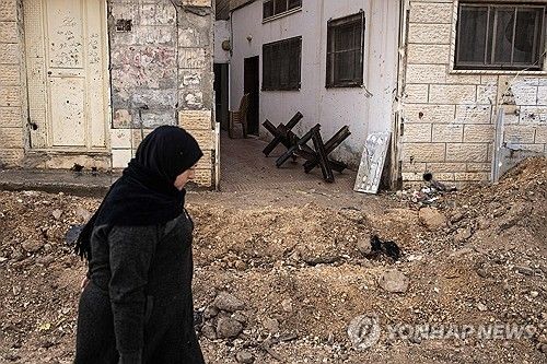 이스라엘군의 군사작전으로 파괴된 서안지구 제닌 주택가를 걷는 팔레스타인 주민이 13일(현지시간) 걷고 있다. 
