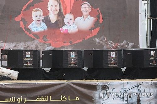 하마스가 인질 시신 인계 전 무대에 관을 올려 전시한 모습