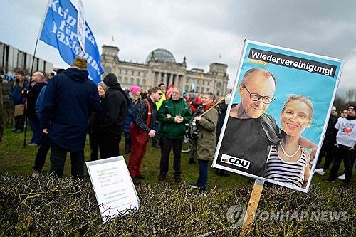 프리드리히 메르츠 CDU 대표와 알리스 바이델 AfD 공동대표(손팻말 안)