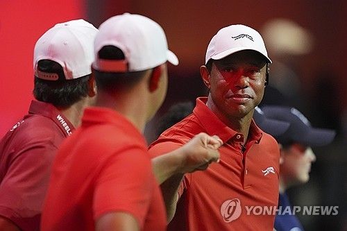 TGL 경기에서 김주형과 주먹을 맞대는 우즈.