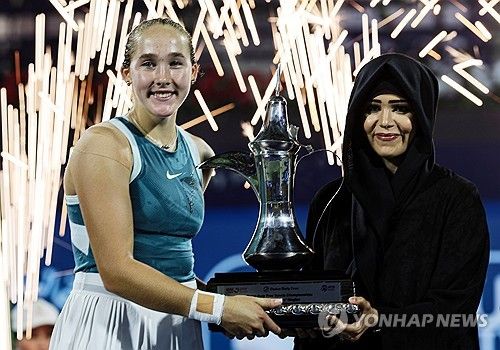 우승 트로피를 받는 안드레예바(왼쪽)