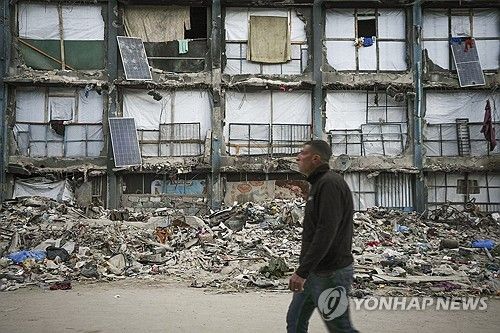 전쟁으로 폐허가 된 건물 앞을 지나가는 팔레스타인 남성