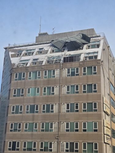 건물에 위태롭게 매달려 있는 양철판 구조물