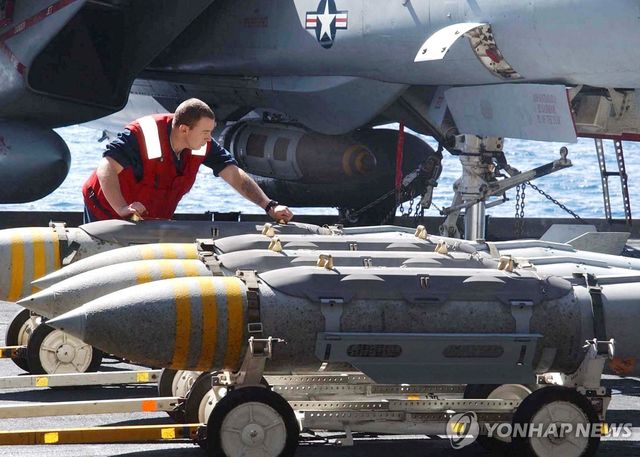 2002년 미 항공모함 존 F. 케네디호 갑판의 F-14 톰캣 전투기 옆에서 2천 파운드급 항공폭탄인 MK-84를 옮기는 미군 병사들