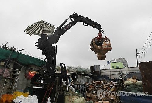 고물상에서 작업하는 굴착기