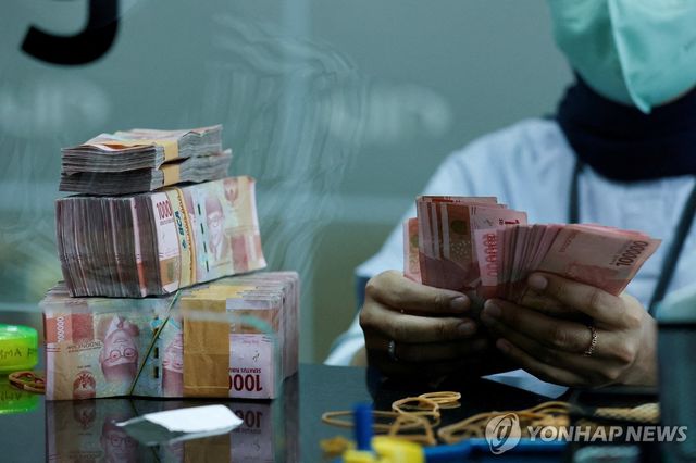 인도네시아 자카르타에 있는 한 환전소 창구에서 직원이 인도네시아 루피아를 세고 있다.