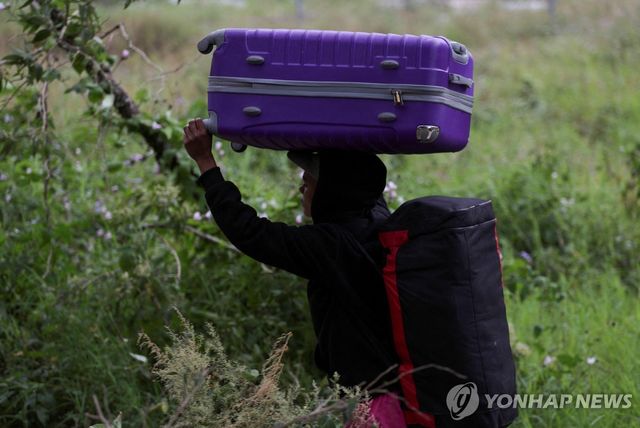 '이고 지고' 온두라스 국경 지대 지나가는 베네수엘라 출신 이민자