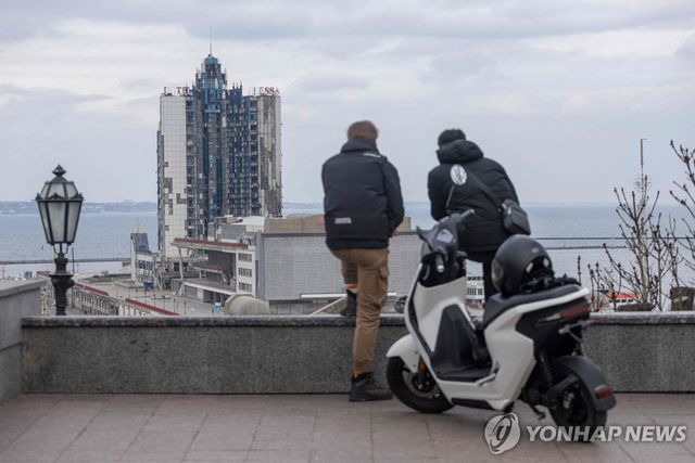 흑해 항구도시 오데사에서 파괴된 오데사 호텔 바라보고 서 있는 두 남성