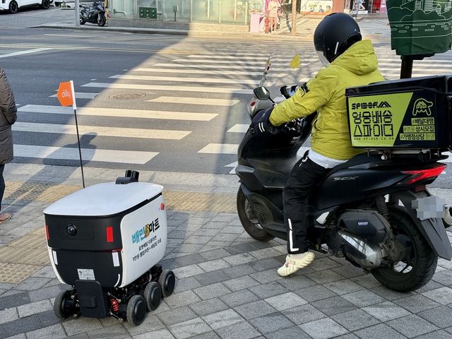 배달 중인 배민 배달 로봇 딜리와 라이더