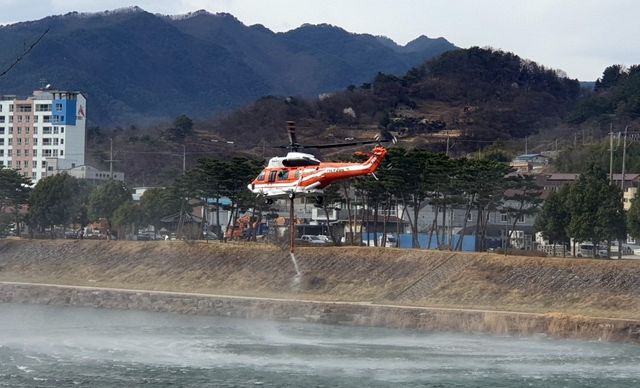 잔불 정리를 위해 물을 퍼나르는 헬기