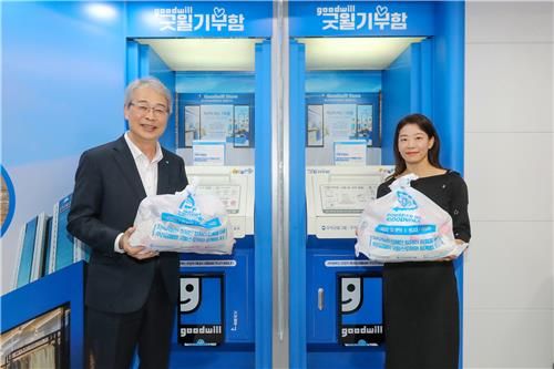 임종룡 우리금융그룹 회장(왼쪽)이 지난 28일 우리은행 소공동지점에 설치된 '굿윌기부함'에 물품을 기부하고 있다. [우리금융 제공]