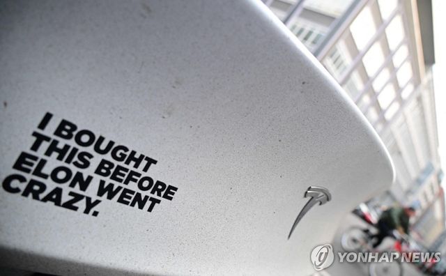 '머스크가 미치기 전에 이걸 샀어요'라고 써진 스티커가 테슬라 차량에 붙어 있는 모습