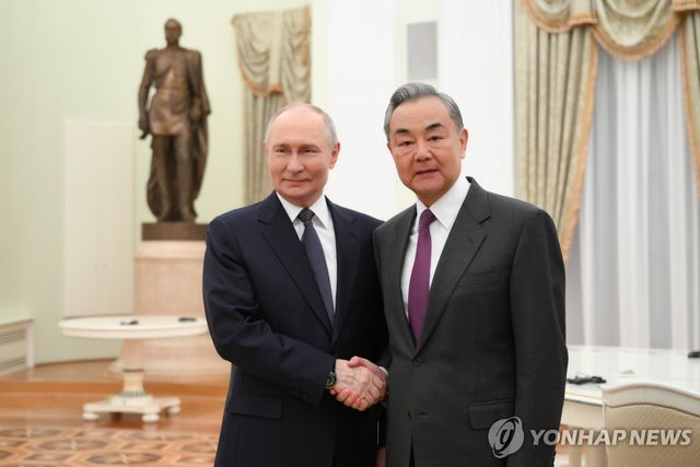 악수하는 블라디미르 푸틴 러시아 대통령과 왕이 중국공산당 중앙외사판공실 주임(외교부장 겸임)