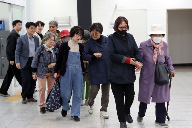 자원봉사자와 함께 행사장 들어서는 시각장애인들
