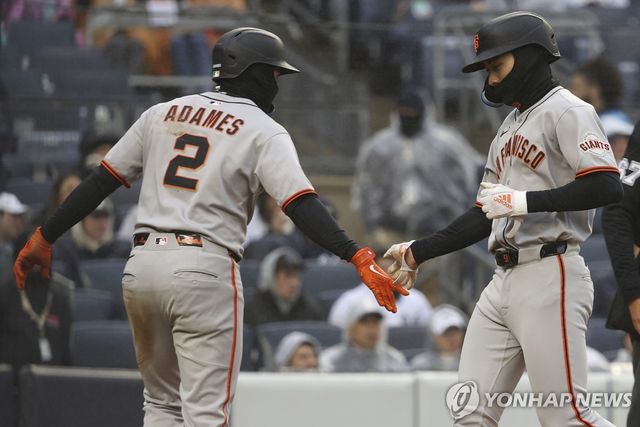 13일 경기에서 동료 선수와 손바닥을 마주치는 이정후(오른쪽)