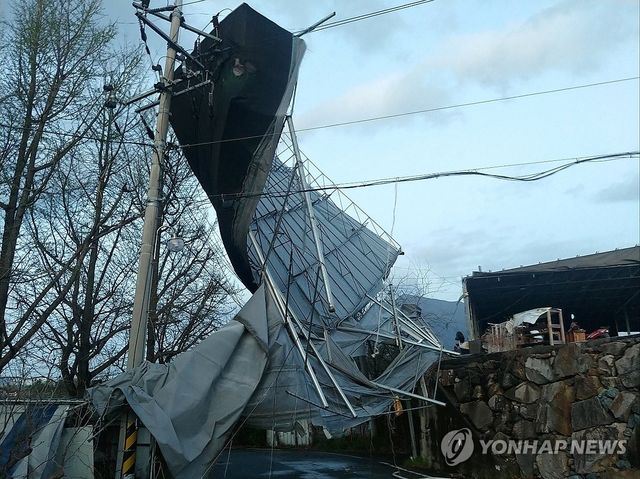 전신주 덮친 폐공장 지붕