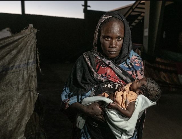 55일 된 아기를 안고 있는 수단 실향민 니마 씨 