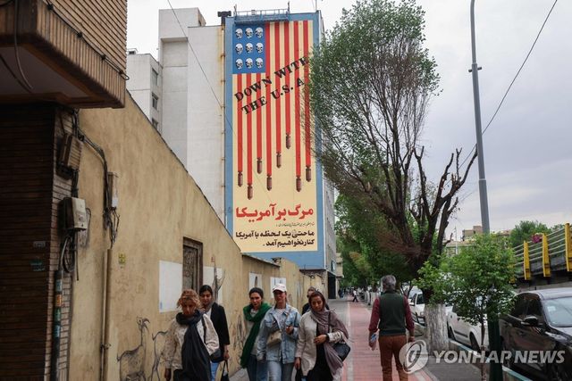 테헤란의 반미 벽화 아래를 지나는 이란 국민들