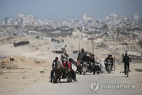 폐허가 된 도시에서 차를 타고 이동중인 가자 주민들 