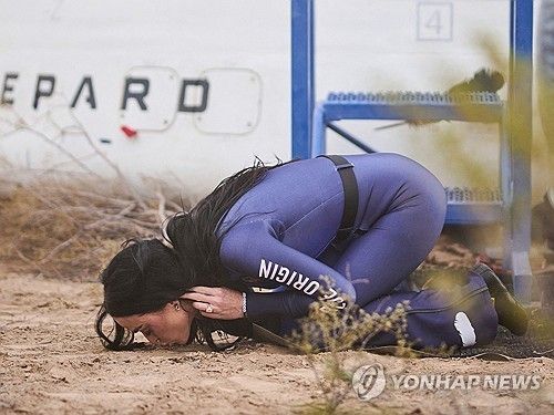 뉴 셰퍼드 비행후 지구에 도착해 땅에 입맞추고 있는 케이티 페리 [AFP 연합뉴스. 블루오리진 제공. 재판매 및 DB 금지]