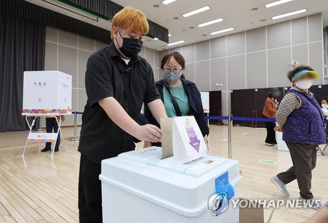 도움받아 소중한 한 표 행사하는 장애인