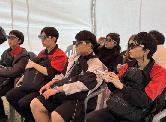 동시 관람 장비를 착용한 학생들이 영화를 관람하는 모습