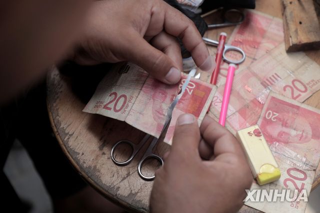 찢어진 화폐를 수리해 재유통하는 가자지구 작업장 [신화 연합뉴스. 자료사진] 