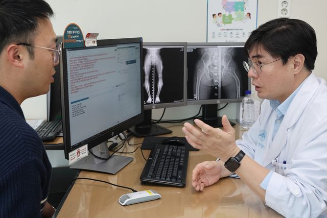 서울아산병원 정형외과 김지완 교수가 AI 진료 음성인식 시스템을 활용해 환자를 진료하고 있다. 전용 마이크를 통해 입력된 의료진과 환자의 음성 데이터가 텍스트로 실시간으로 기록되고 있다. [서울아산병원 제공]