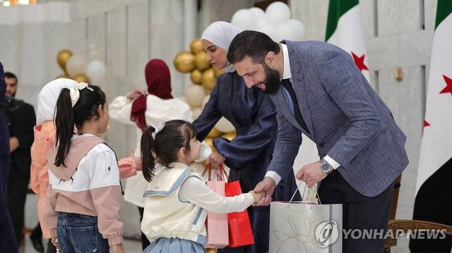 어린이 손 잡은 아메드 알샤라 시리아 임시대통령(오른쪽)