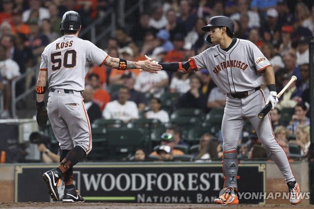 휴스턴과 경기에서 동료 선수와 손바닥을 마주치는 이정후(오른쪽)