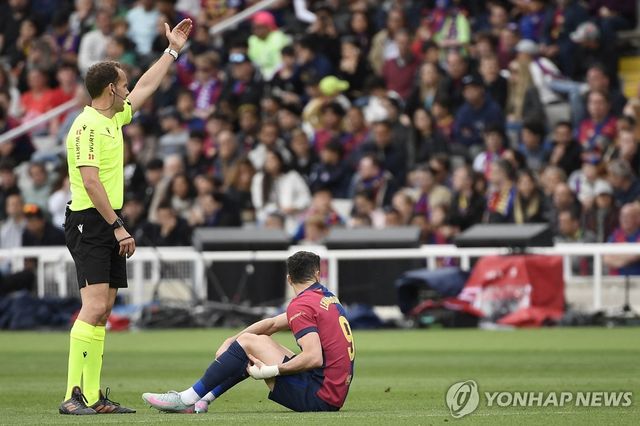 왼쪽 허벅지를 잡고 주저앉은 바르셀로나의 로베르트 레반도프스키