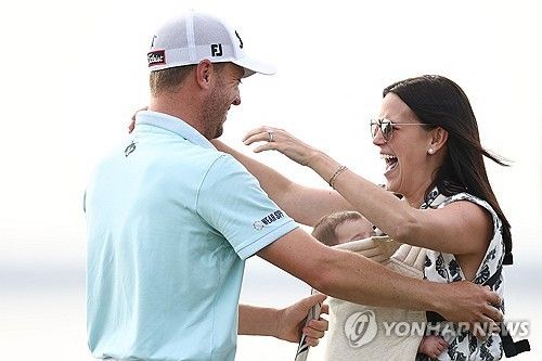 우승 퍼트를 넣고 아내, 딸과 포옹하는 저스틴 토머스.