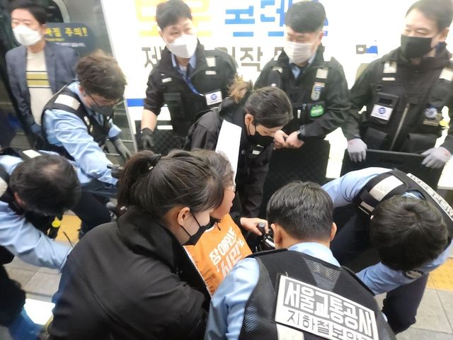 서울교통공사 지하철보안관들이 이형숙 전장연 상임공동대표를 지하철 4호선 혜화역 승강장에서 끌어내고 있다. [촬영 김준태] 