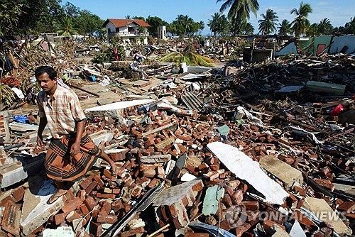 2004년 지진해일로 쑥대밭이 된 함반토타 마을을 한 남성이 지나가고 있다.