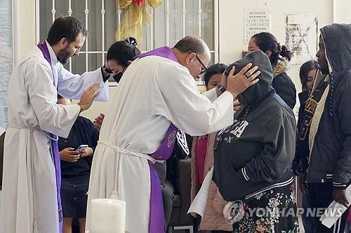 이주민을 축복하고 있는 예수회 신부들 